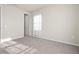 This bedroom features neutral walls and carpet, a large window, and closet access at 2290 Sw Raven Ridge Rd, Clermont, FL 34715