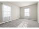 This bedroom features neutral walls and carpet, and two windows with white curtains at 2290 Sw Raven Ridge Rd, Clermont, FL 34715