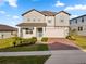 Charming two-story home featuring a brick driveway and a well-manicured front lawn with lush greenery at 2290 Sw Raven Ridge Rd, Clermont, FL 34715