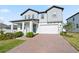Beautiful two-story home featuring a brick driveway, attached garage, and well maintained landscaping at 2290 Sw Raven Ridge Rd, Clermont, FL 34715