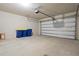 Spacious two-car garage with concrete floor, automatic door opener and three blue recycle bins at 2290 Sw Raven Ridge Rd, Clermont, FL 34715
