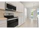 Bright kitchen featuring stainless steel oven and microwave, white cabinets, and access to the outdoors at 2290 Sw Raven Ridge Rd, Clermont, FL 34715