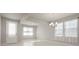 Bright and airy living room featuring a modern chandelier, large windows, and light wood-look flooring at 2290 Sw Raven Ridge Rd, Clermont, FL 34715