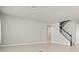 Spacious living room featuring neutral paint, wood-look tile floors, and staircase with black handrail at 2290 Sw Raven Ridge Rd, Clermont, FL 34715