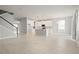 Large open-concept living space flowing into the kitchen with light tile flooring throughout the downstairs at 2290 Sw Raven Ridge Rd, Clermont, FL 34715