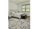 Bright bedroom featuring a wooden bed frame, neutral bedding, an area rug, and natural light through window at 2301 Avellino Ave, St Cloud, FL 34771