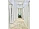 Well-lit hallway featuring a neutral color scheme and tile flooring at 2301 Avellino Ave, St Cloud, FL 34771