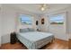 Bright bedroom with wood floors, two large windows, and simple decor at 2811 S Peninsula Dr, Daytona Beach, FL 32118