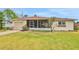 Charming single-story home featuring a screened front porch, lush lawn, and an attached one-car garage at 2811 S Peninsula Dr, Daytona Beach, FL 32118