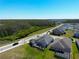 An aerial view shows a house with a screened lanai looking onto a green lawn and street at 2942 Wordsmith Rd, Kissimmee, FL 34746