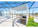 Entertain in this screened in outdoor kitchen, featuring seating and modern grill at 2942 Wordsmith Rd, Kissimmee, FL 34746