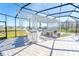 Screened outdoor kitchen with grill, counter seating and hardscaped flooring is perfect for entertaining at 2942 Wordsmith Rd, Kissimmee, FL 34746