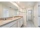 Bright bathroom featuring double sinks, a large mirror, and a glass-enclosed shower at 2962 Firebush Way, Clermont, FL 34711
