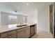 Bright kitchen features an island with stainless steel appliances, double sink, and wood-look tile floors at 2962 Firebush Way, Clermont, FL 34711
