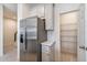 Kitchen area with a stainless steel refrigerator and a pantry with plenty of storage space at 2962 Firebush Way, Clermont, FL 34711