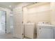 Convenient laundry room with washer and dryer hookups, shelving, and tiled flooring at 2962 Firebush Way, Clermont, FL 34711