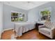 Cozy bedroom with a bed, chair, wood floors, and natural light from the surrounding windows at 3000 Amherst Ave, Orlando, FL 32804