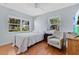 Cozy bedroom with a bed, chair, wood floors, and natural light from the surrounding windows at 3000 Amherst Ave, Orlando, FL 32804