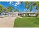 Charming single-story home featuring a manicured lawn, mature trees, and inviting curb appeal on a sunny day at 3000 Amherst Ave, Orlando, FL 32804