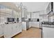 Well-lit modern kitchen boasts white cabinets, stainless steel appliances, and tile floors at 3000 Amherst Ave, Orlando, FL 32804
