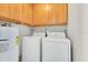 Convenient laundry area featuring a washer, dryer, water heater, and storage cabinets above at 3000 Amherst Ave, Orlando, FL 32804