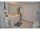 Bright bathroom featuring a vanity with storage, large mirror and a closet with bi-fold doors at 308 Tangerine St, Altamonte Springs, FL 32701