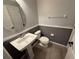 Half-bathroom with a pedestal sink, toilet, and framed oval mirror at 3665 Brighton Park Cir, Orlando, FL 32812
