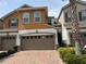 Two-story home featuring an attached two-car garage and a red brick driveway at 3665 Brighton Park Cir, Orlando, FL 32812