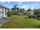 Well-maintained backyard with lush green lawn, mature trees, and storage shed at 3840 Cedarwaxwing Ave, Orlando, FL 32822
