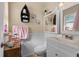 Well-lit bathroom featuring a vanity with storage, a toilet, and decorative shelving at 3840 Cedarwaxwing Ave, Orlando, FL 32822