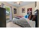Well-lit bedroom featuring a bed, a window, and decorated with wall art at 3840 Cedarwaxwing Ave, Orlando, FL 32822