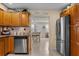 Open kitchen with stainless steel appliances and wood cabinets, leading to dining area at 3840 Cedarwaxwing Ave, Orlando, FL 32822