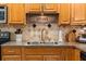 Close-up of the kitchen sink and cabinets, complemented by tiled backsplash and decor at 3840 Cedarwaxwing Ave, Orlando, FL 32822