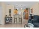 Inviting living space flowing into the kitchen, featuring tile floors and a breakfast bar at 3840 Cedarwaxwing Ave, Orlando, FL 32822