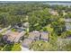Aerial view of a home showcasing the backyard pool, mature trees, and a serene lake in the distance at 4174 Fallwood Cir, Orlando, FL 32812