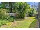 Green backyard with lush landscaping, a well-maintained lawn, and a privacy fence at 4174 Fallwood Cir, Orlando, FL 32812