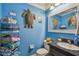 Bright blue bathroom features beach decor, white fixtures, and granite topped vanity at 4174 Fallwood Cir, Orlando, FL 32812