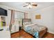 Comfortable bedroom with wood floors, ceiling fan, and view to the outside at 4174 Fallwood Cir, Orlando, FL 32812