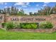 Brick sign for Lake Conway Woods community with manicured landscaping and bright blue skies at 4174 Fallwood Cir, Orlando, FL 32812