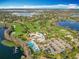 Stunning aerial view of a community with a golf course, clubhouse, pools, parking, and lakefront access at 5067 Latrobe Dr, Windermere, FL 34786