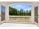 A sun-drenched balcony features classic white balusters with views of lush green trees and a bright blue sky at 5067 Latrobe Dr, Windermere, FL 34786