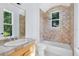 Bright bathroom featuring a single vanity, toilet, combination bathtub and shower, and tile accents at 5067 Latrobe Dr, Windermere, FL 34786