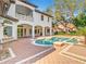 Home's backyard featuring pool, spa, fountains, covered porch with arches, brick pavers and landscaping at 5067 Latrobe Dr, Windermere, FL 34786