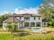 Elegant two-story home showcasing a pristine pool, meticulously landscaped yard, and a charming architectural design at 5067 Latrobe Dr, Windermere, FL 34786