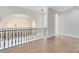Second floor landing with hardwood floors, wrought iron railing, and archways at 5067 Latrobe Dr, Windermere, FL 34786