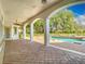 Covered patio with brick pavers, stately columns, with views of the pool, spa, and large backyard at 5067 Latrobe Dr, Windermere, FL 34786