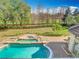 In-ground swimming pool, with mature trees, a perfectly manicured lawn and perimeter shrubs at 5067 Latrobe Dr, Windermere, FL 34786