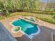 Beautiful backyard showcasing in-ground pool and spa surrounded by large, professionally landscaped yard at 5067 Latrobe Dr, Windermere, FL 34786