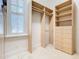 Neat walk-in closet featuring custom organizers, shelving, drawers, hanging, and a window with plantation shutters at 5067 Latrobe Dr, Windermere, FL 34786