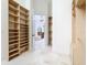 Large walk-in closet with custom shelving leading to a bathroom with a chandelier over a soaking tub at 5067 Latrobe Dr, Windermere, FL 34786